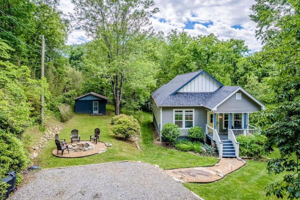 a cottage in the woods with a yard at Hilltop Hideaway in Asheville
