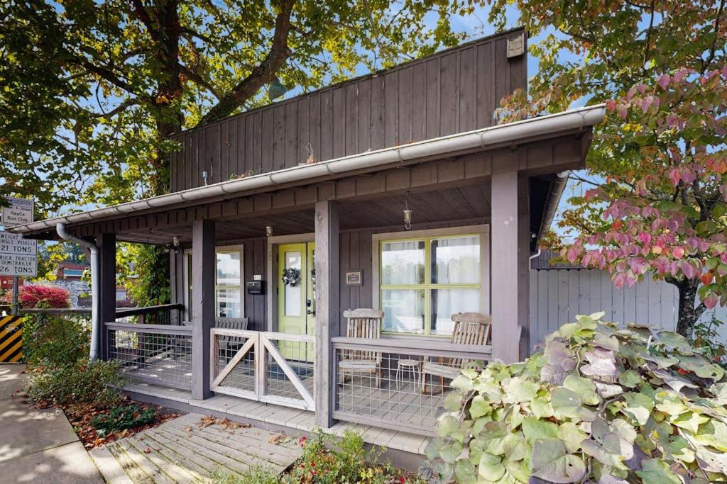 a small house with a porch and two chairs at Sassafras Cottage in Waynesville