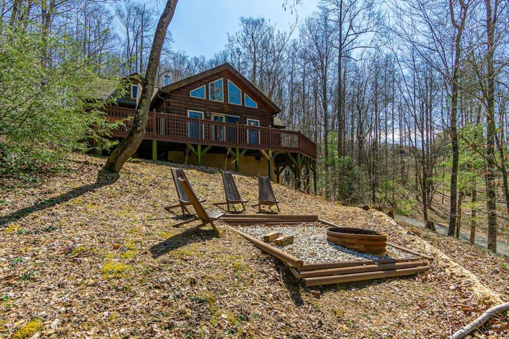 a house with lounge chairs in front of it at The Lovely Cabin in Black Mountain