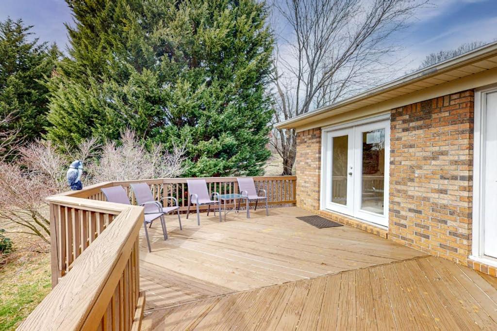a deck with chairs and tables on a house at Come Together Place in Candler