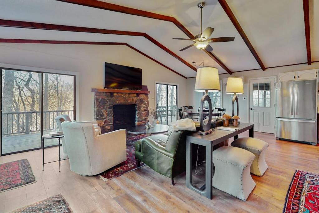 a living room with a fireplace and a table and chairs at The Nunv Cabin in Brevard