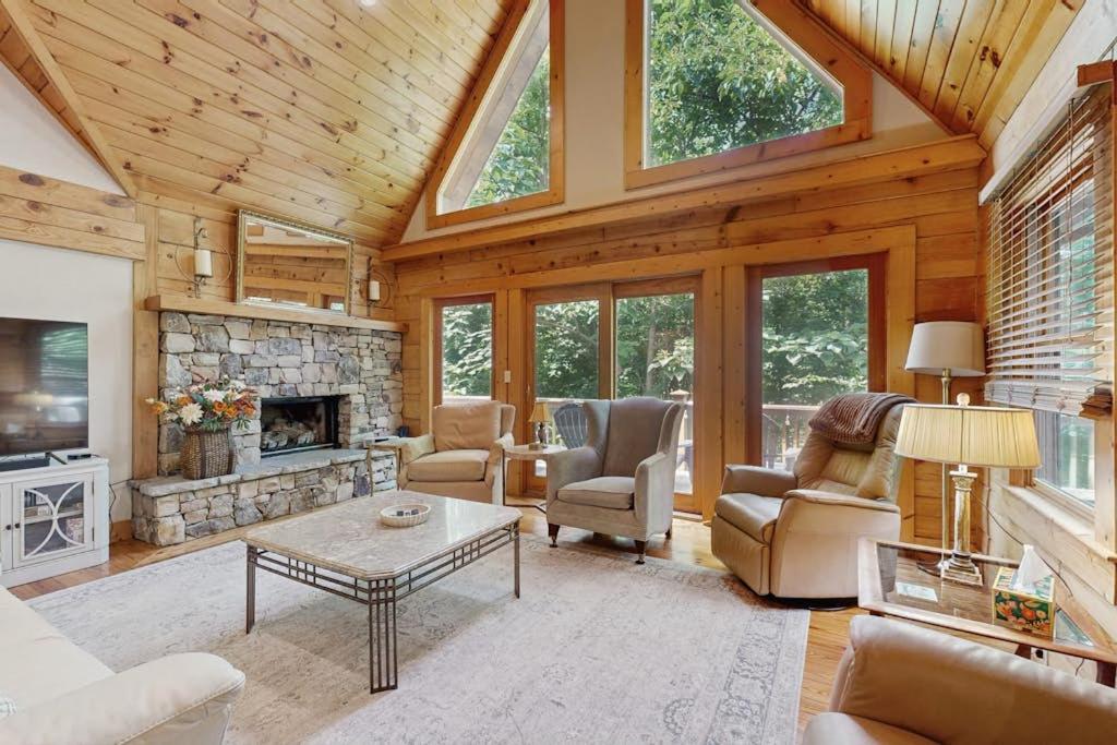 a living room filled with furniture and a stone fireplace at Bird's Nest in Saluda