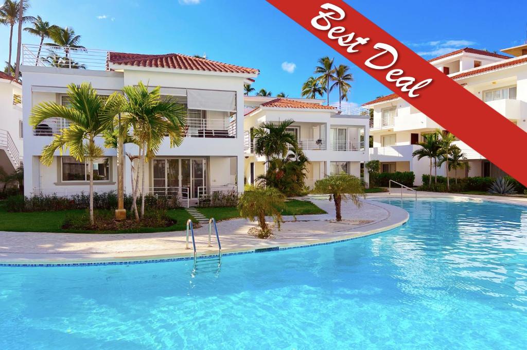 a swimming pool in front of a building at PASADENA VIBES - VILLAS and SUITES - playa LOS CORALES in Punta Cana
