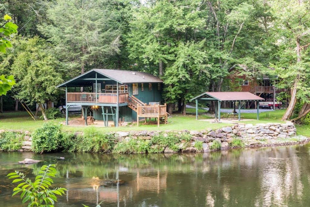 ein Haus mit Terrasse direkt an einem Gewässer in der Unterkunft River Romance in Sylva