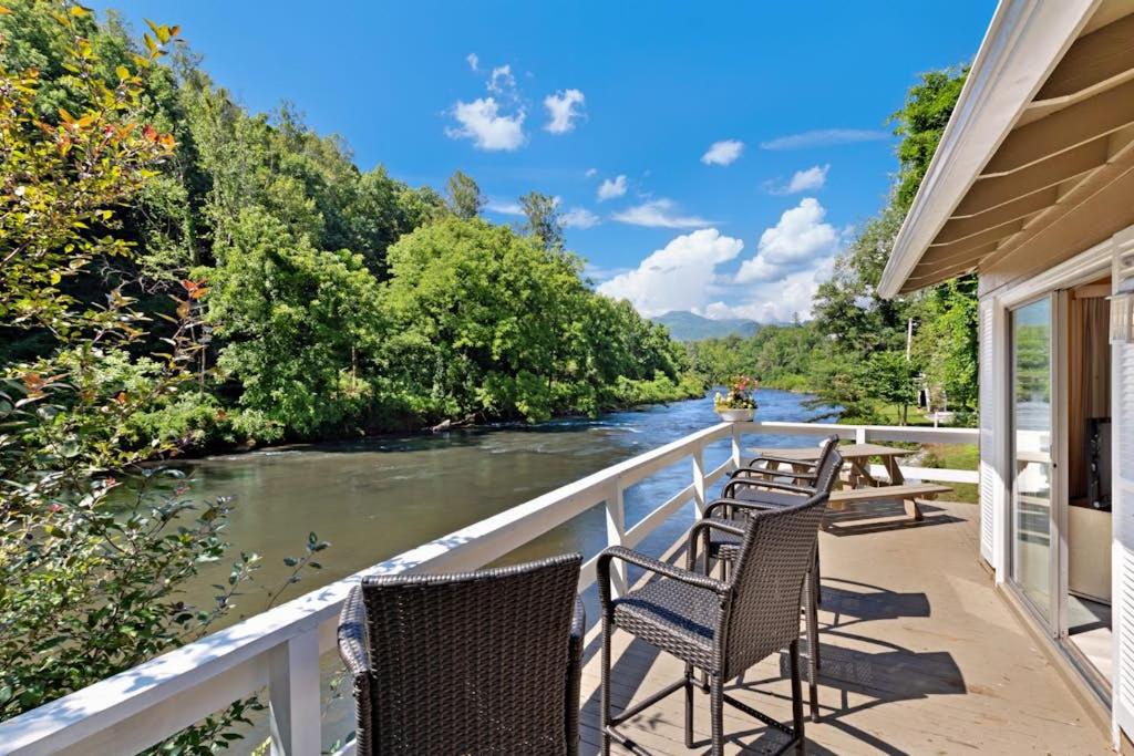 a row of chairs sitting on a balcony overlooking a river at 2 Bed 1 Bath Vacation home in Sylva in Sylva