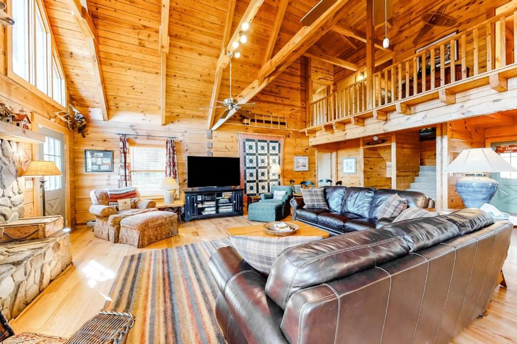 a living room with a leather couch and a television at Timberidge Lodge in Sylva