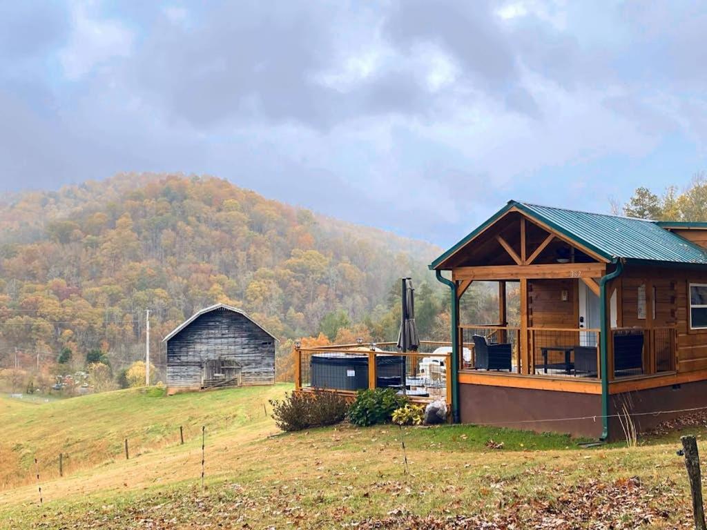 a house and a barn with a hill in the background at Phobos Cabin in Mars Hill