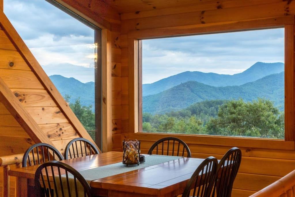 a dining room with a table and chairs and a large window at 4 Bed 4 Bath Vacation home in Sylva in Sylva