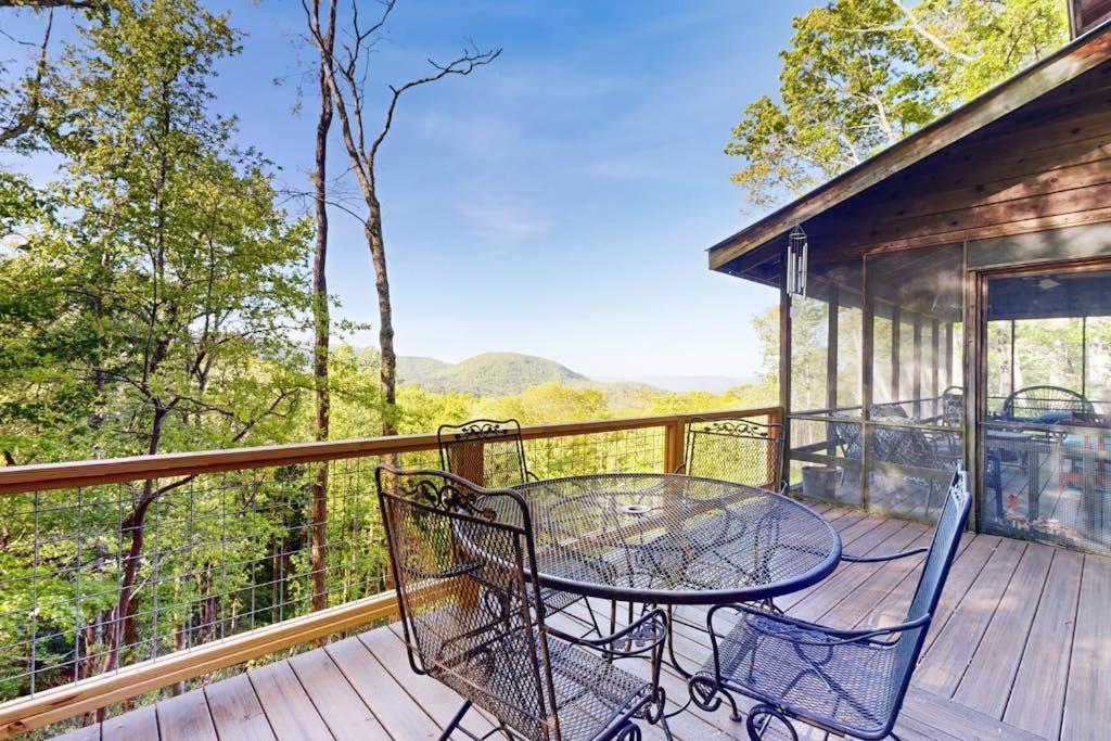 a patio with a table and chairs on a deck at Merrywoode in Lake Toxaway