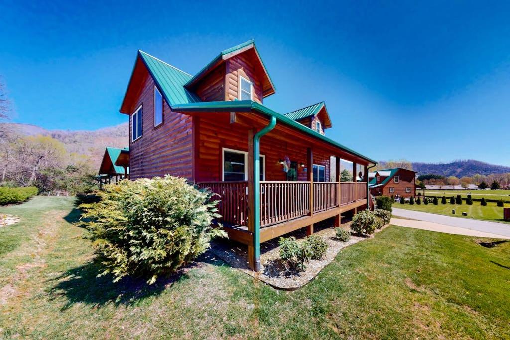 a red house with a green roof on a yard at The Mountain Haven in Maggie Valley