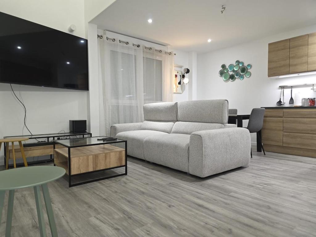 a living room with a couch and a table at Duplex Rooftop premium - 4 chambres - Evry in Courcouronnes