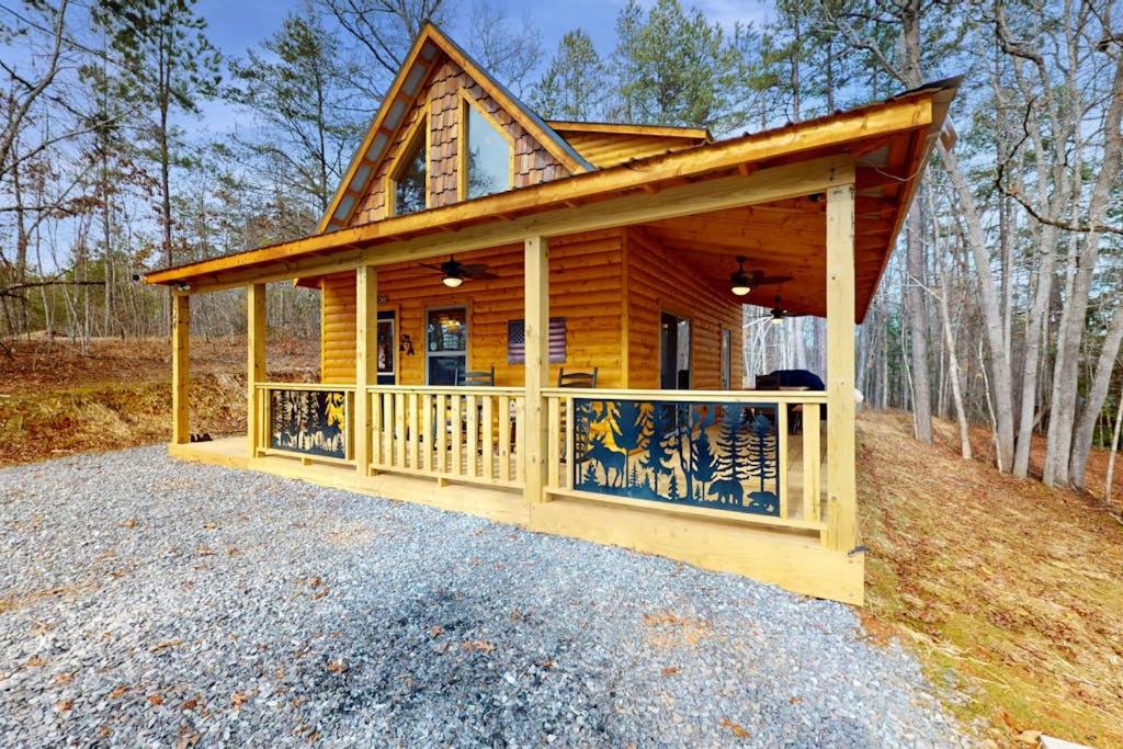 a log cabin with a porch and a deck at Whispering Pines in Murphy