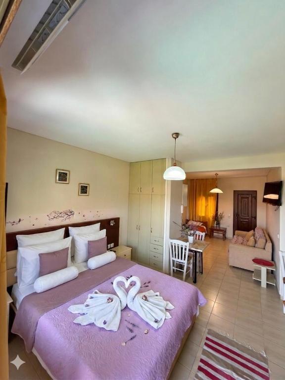 a bedroom with a large bed with towels on it at Ta Kalamakia Apartments in Vatera