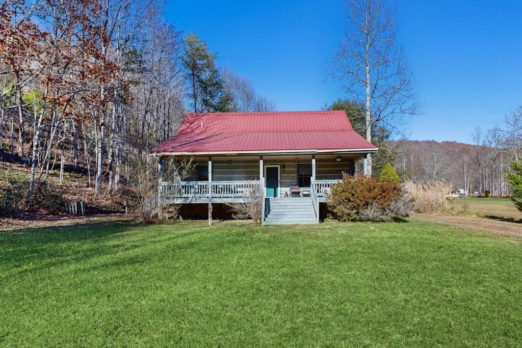 a small house with a red roof on a grass field at Pebble on The Creek in Whittier