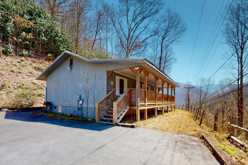 a small house with a porch and a fence at Elk Valley Lodge in Maggie Valley