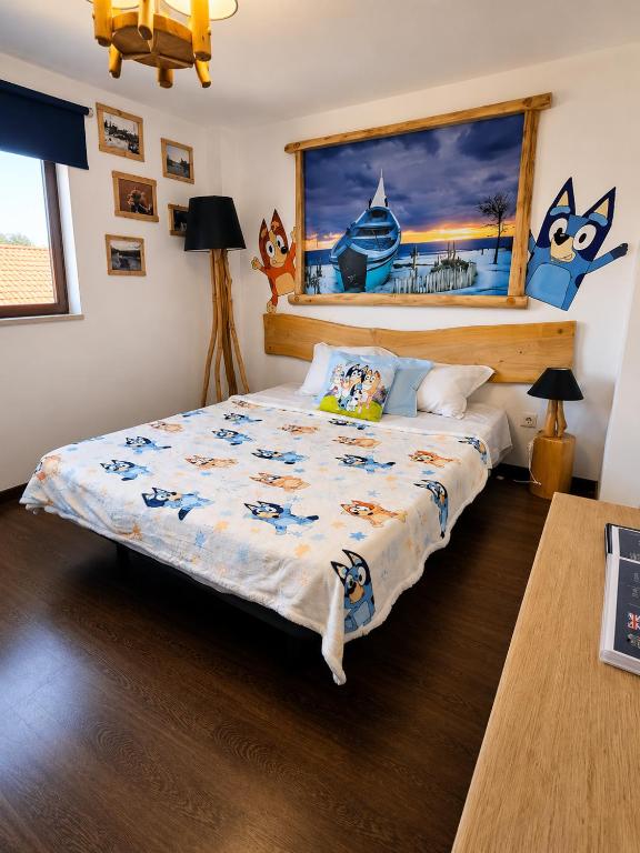 a bedroom with a bed with a blue and white comforter at Atlantic Spot Guest House in Praia de Mira