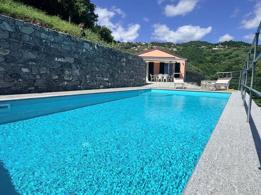 a swimming pool in front of a stone wall at House Over The Paradise in Moneglia