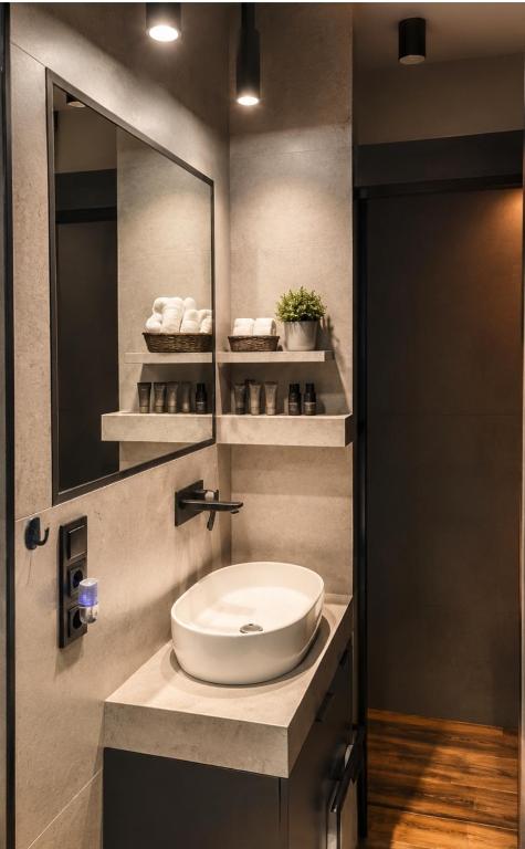 a bathroom with a sink and a mirror at Apartamenty Zator Jaśminowa in Zator