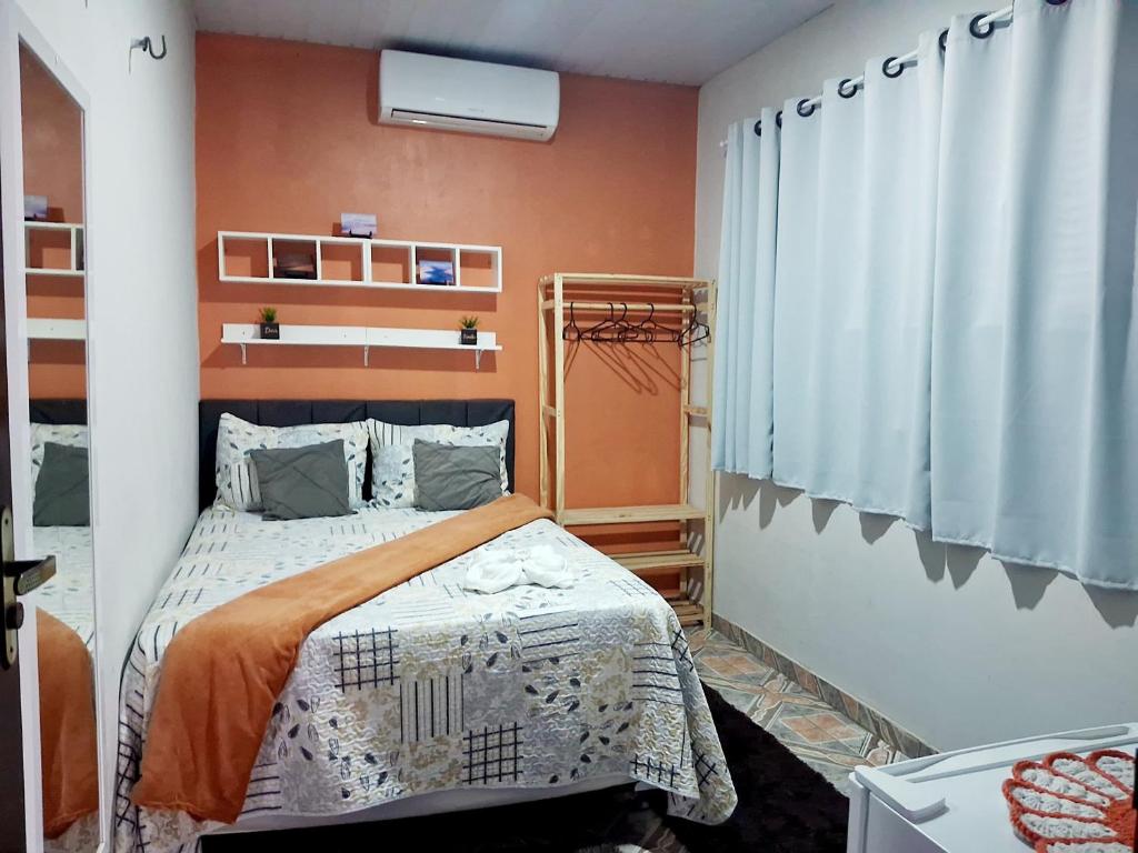 a small bedroom with a bed and a window at Hospedagem Aconchego do Lar in Barreirinhas