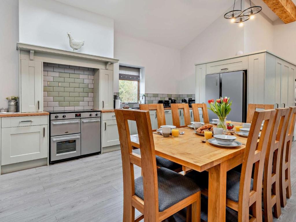 a kitchen with a wooden dining table and chairs at 4 Bed in Forton oc-81290 in Forton