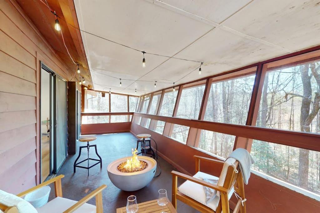a room with a fire pit in a house with windows at The Crocket Fortune in Murphy
