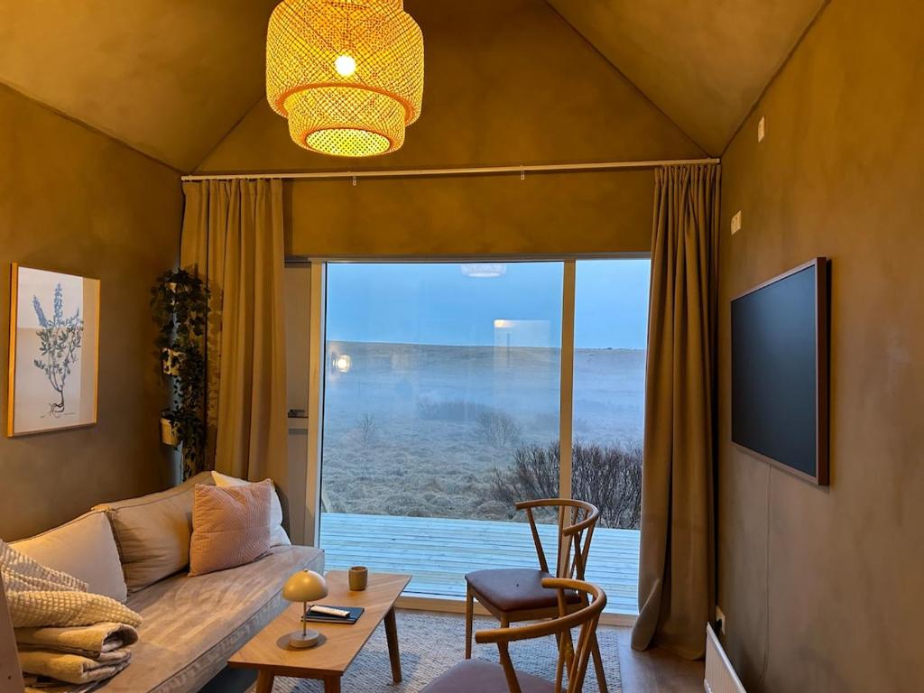 a living room with a couch and a large window at Cozy cottage with a view in Hella