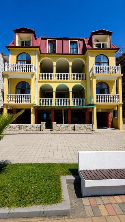 a large yellow building with a red roof at Sunny Beach Hotel in Kobuleti