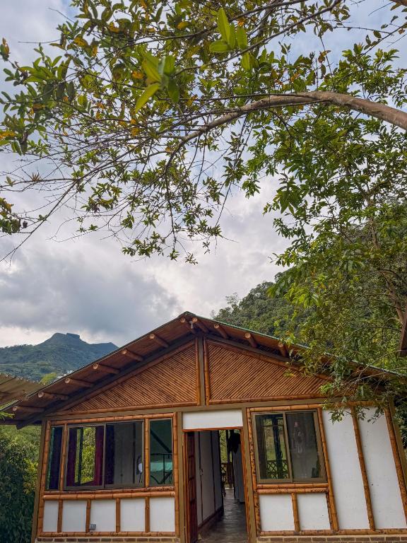 a house with a tree at Cabaña ALAK in La Vega