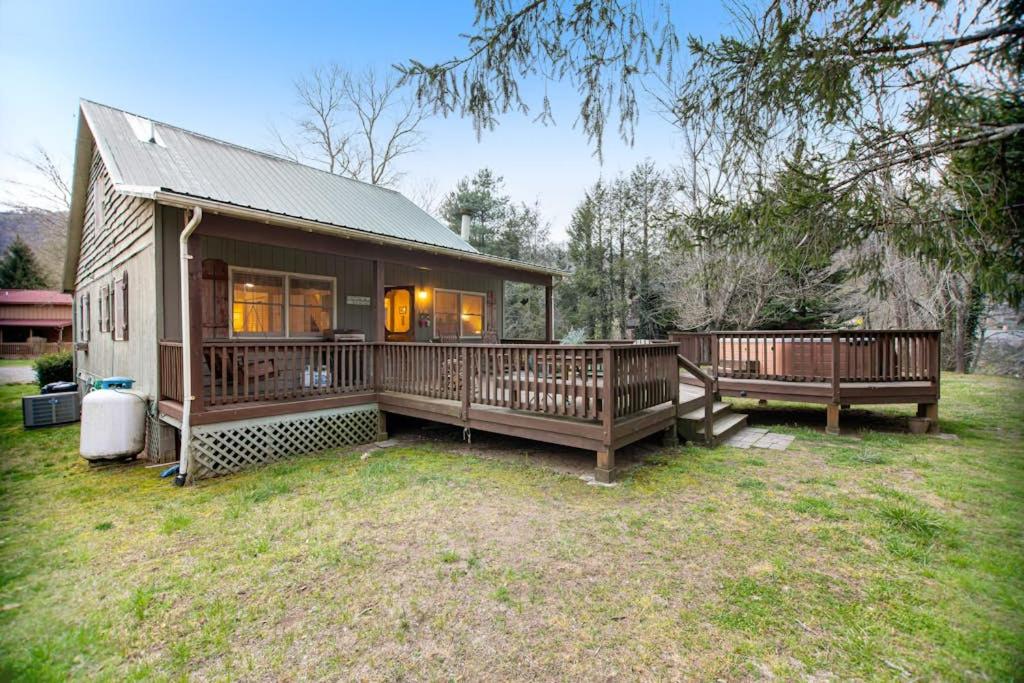 a home with a large porch and a house at Along the River Cottage in Cullowhee