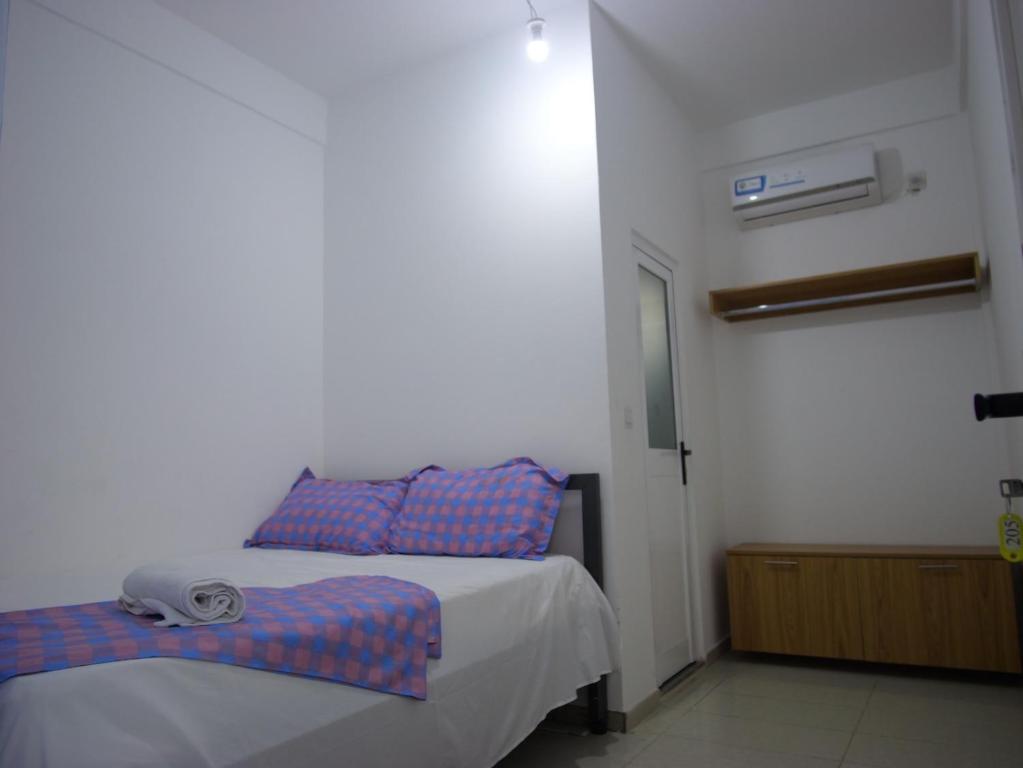 a bedroom with a bed with blue and red pillows at Ndjuly Residencial in Luanda