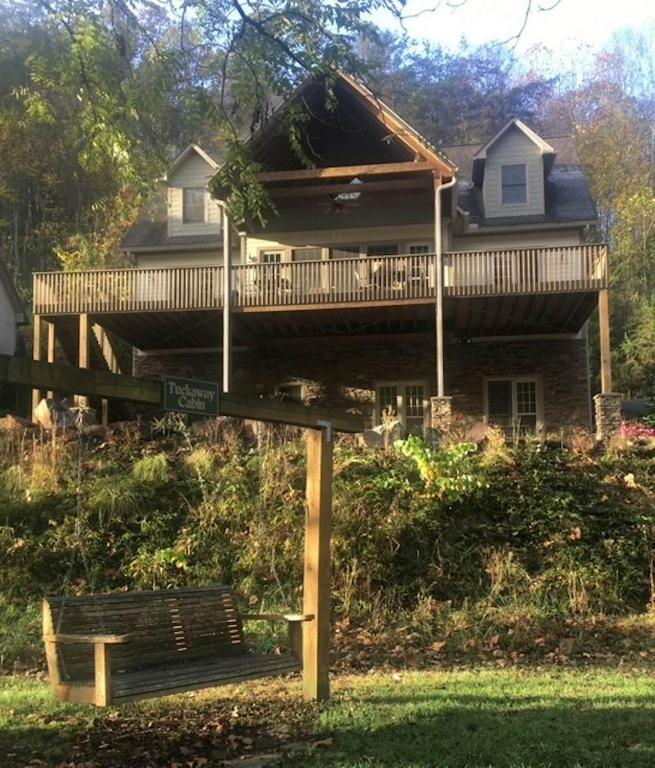 a house with a deck and a bench in front of it at Tuckaway Retreat in Sylva