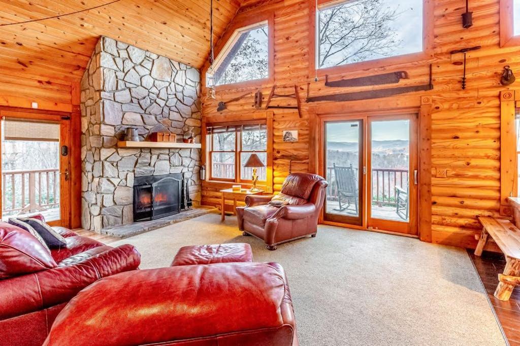 a living room with a stone fireplace in a log cabin at Cloud Walk in Sylva