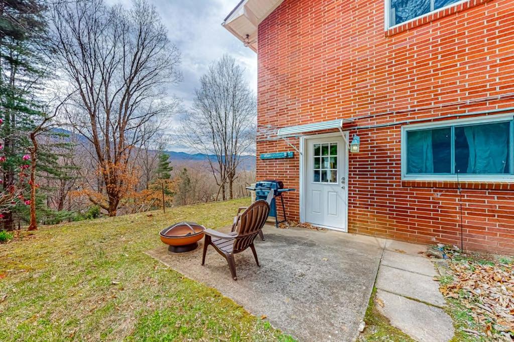 a bench sitting outside of a brick house at Cozy Mountain Hideaway in Waynesville