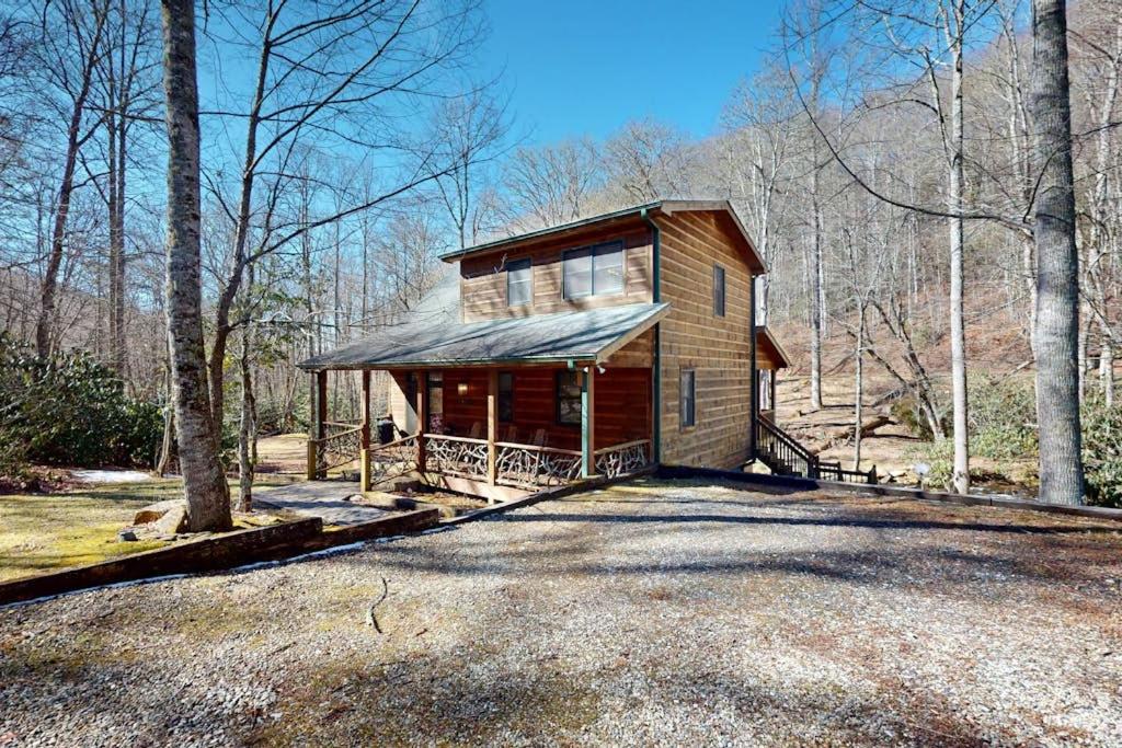 a small wooden house in the middle of a forest at The Rushing Creek Cabin in Topton