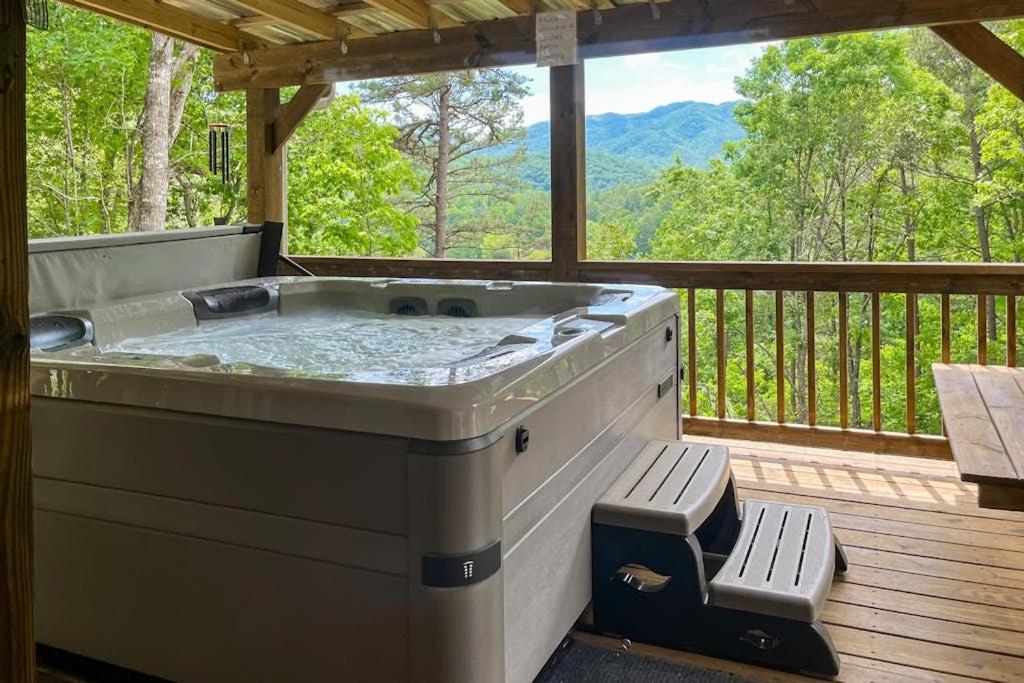 a hot tub on a deck with a view of the mountains at Simple blessings in Bryson City