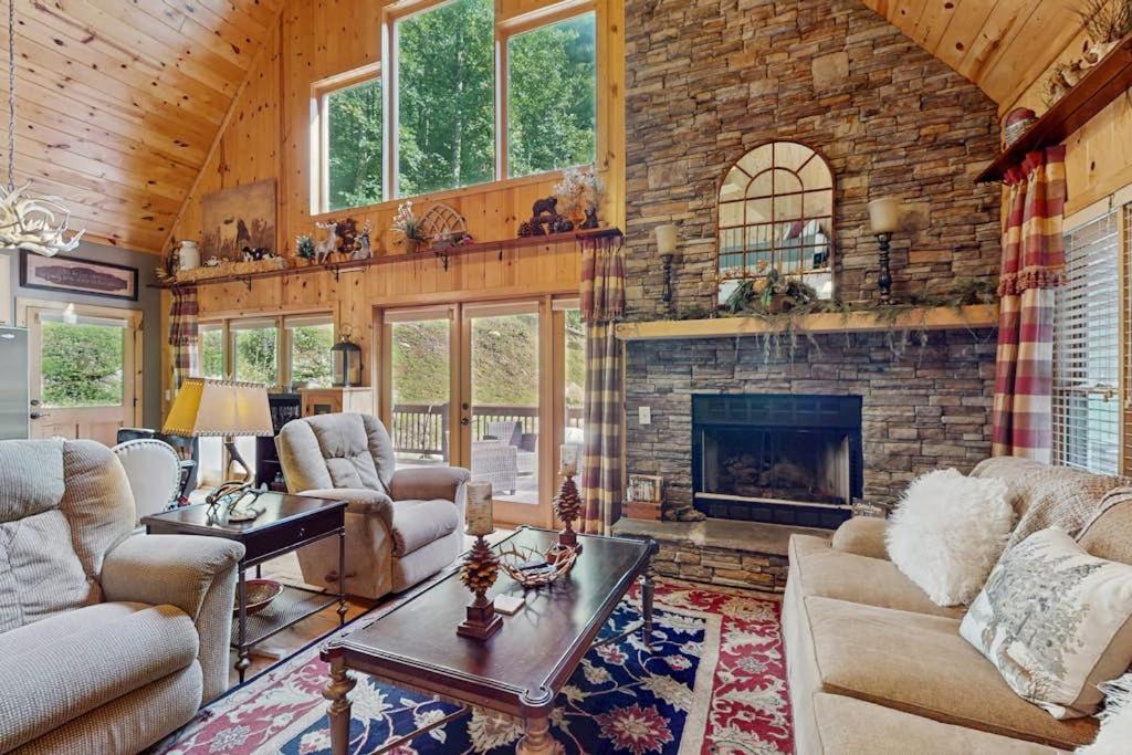 a living room with a stone fireplace in a house at Peak and Pond Retreat in Scaly Mountain