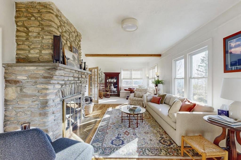 a living room with a large stone fireplace at Huckleberry Hill in Waynesville