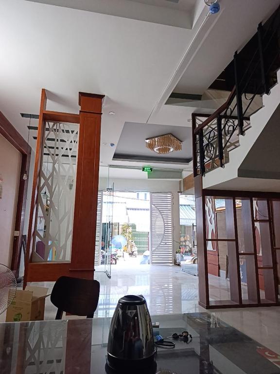a living room with a glass table and a staircase at QN Home in Quy Nhon