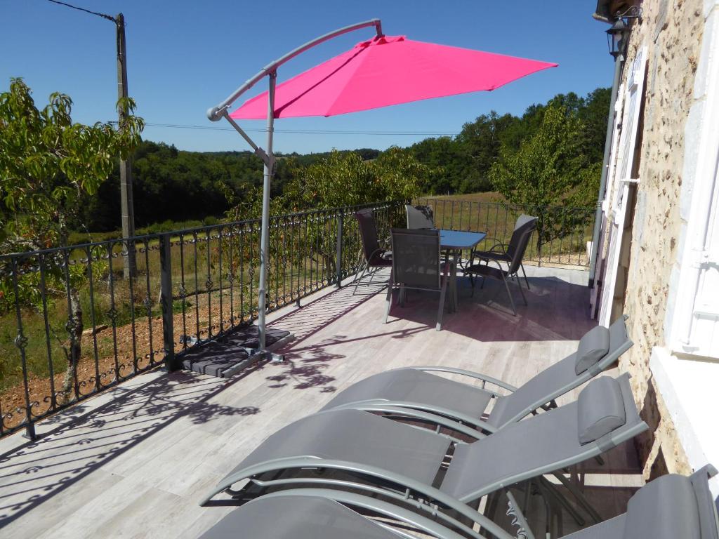 a patio with a table and an umbrella at Gîtes de Pouzelande in Notre-Dame-de-Sanilhac