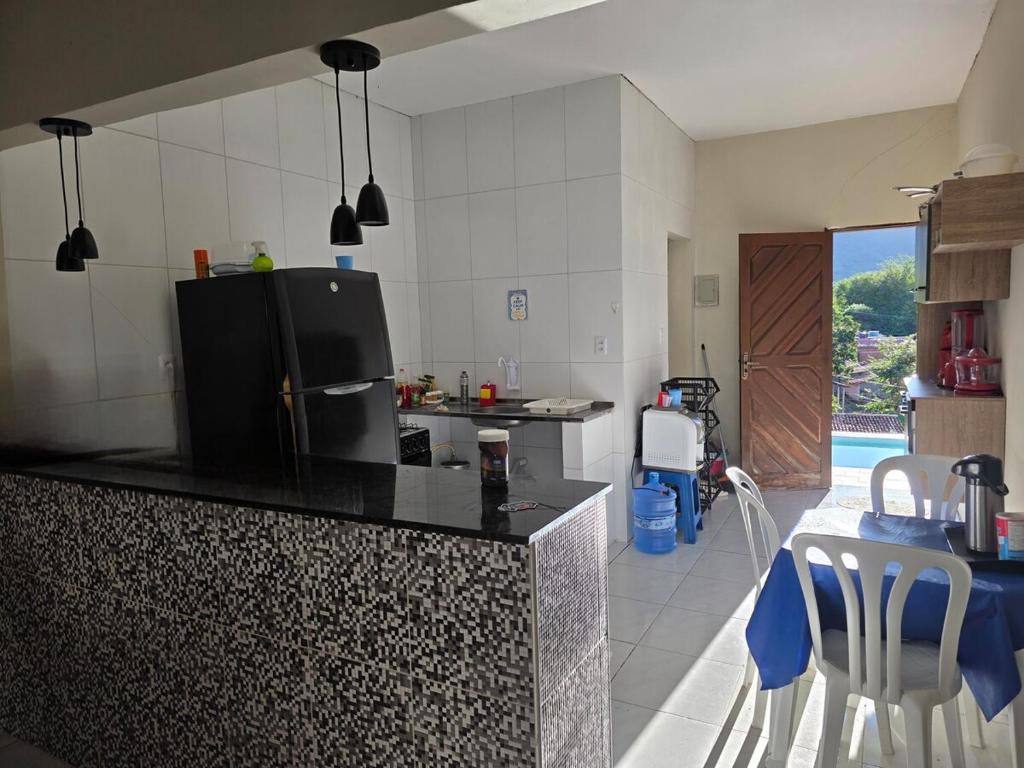 a kitchen with a refrigerator and a table and chairs at Mirante in Crato