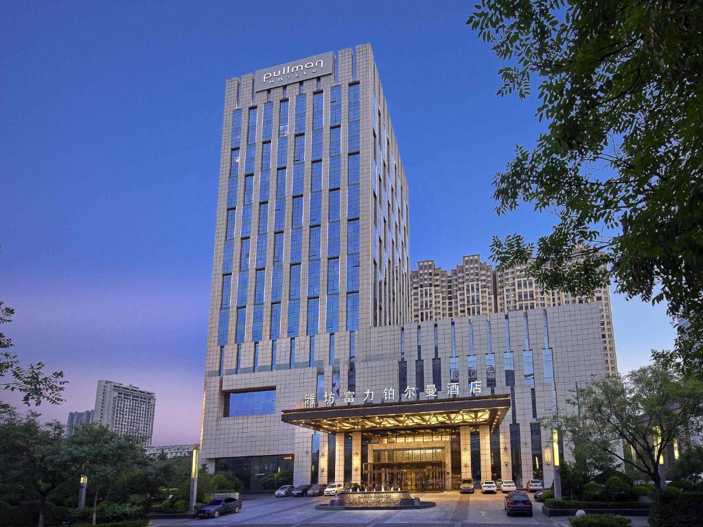 a tall building with a sign on top of it at Pullman Weifang in Weifang