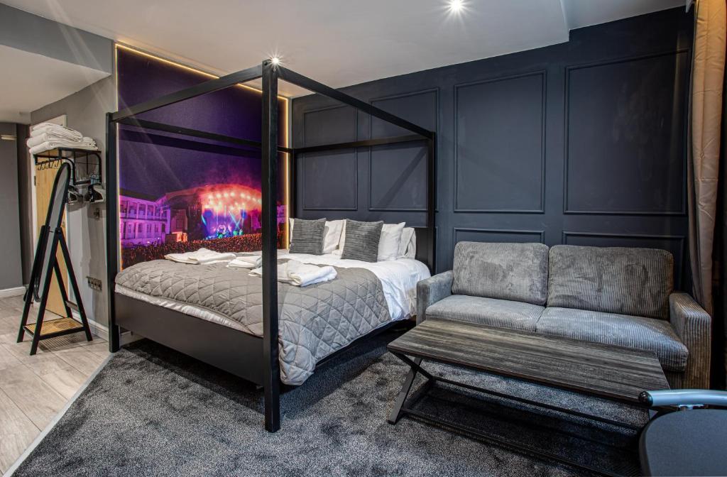 a bedroom with a canopy bed and a couch at The Piece Hall Harmony Designer Studio - Superking in Halifax