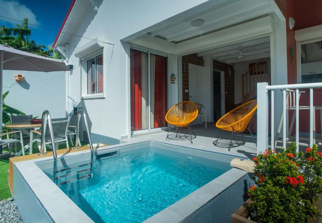a swimming pool with two chairs and a table at Villa piscine privée Grand-Bourg proche plage in Grand-Bourg