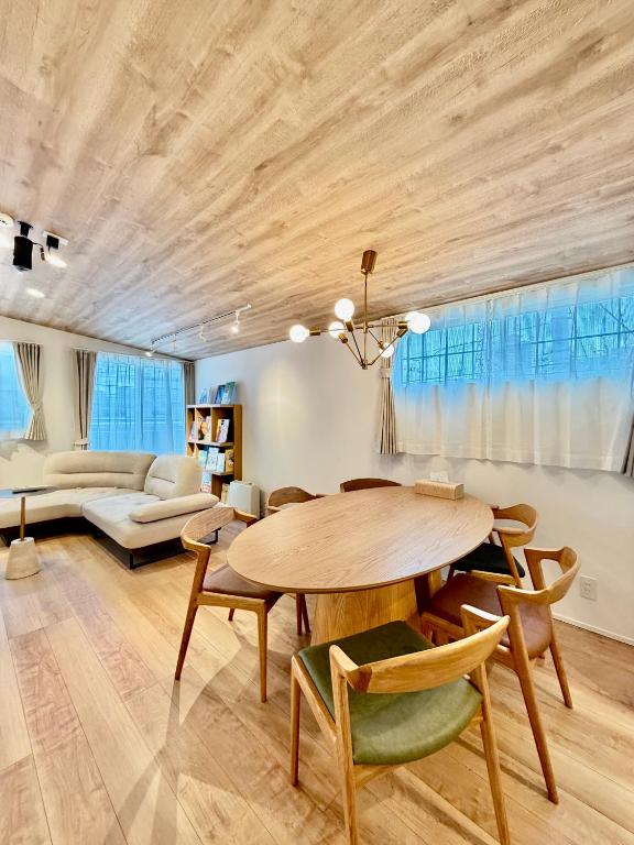 a dining room with a wooden table and chairs at BookHouse in Takasaki