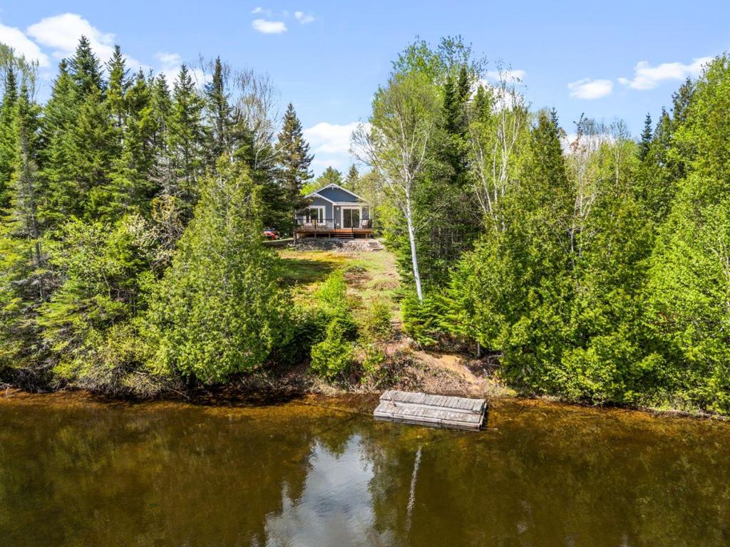 an aerial view of a house in the middle of a lake at La perle bleu in Rivière-à-Pierre