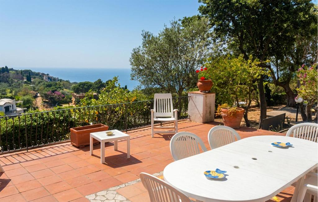 a patio with white tables and chairs and the ocean at Villa Marina in Anacapri