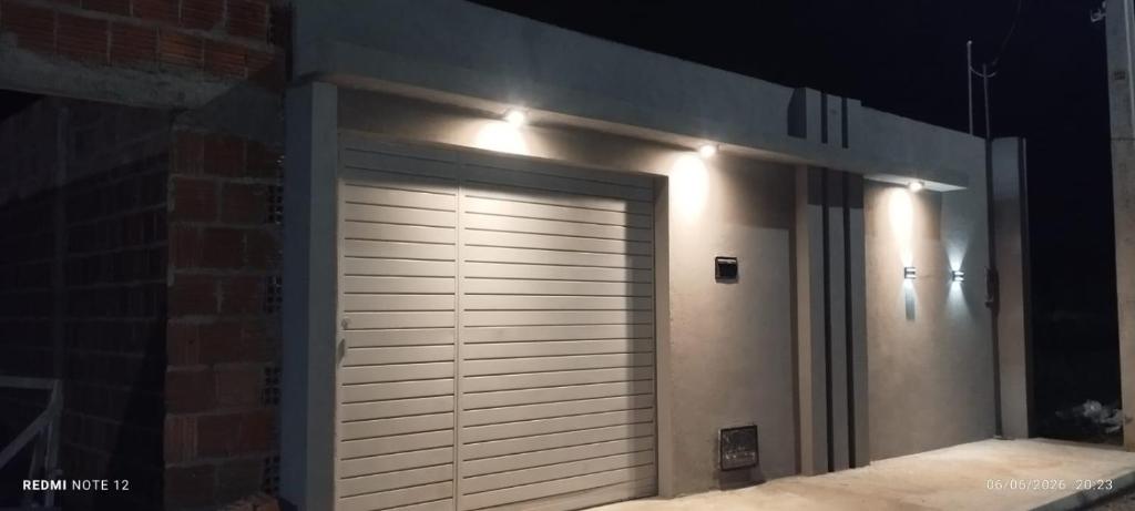 a garage door with lights on the side of a building at beach house in Pontal de Coruripe in Coruripe