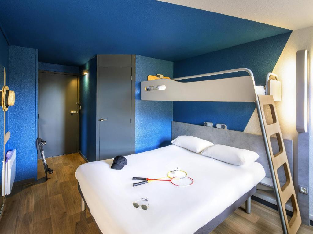 a bedroom with a bed with a bunk bed at ibis budget Grenoble Voreppe in Voreppe