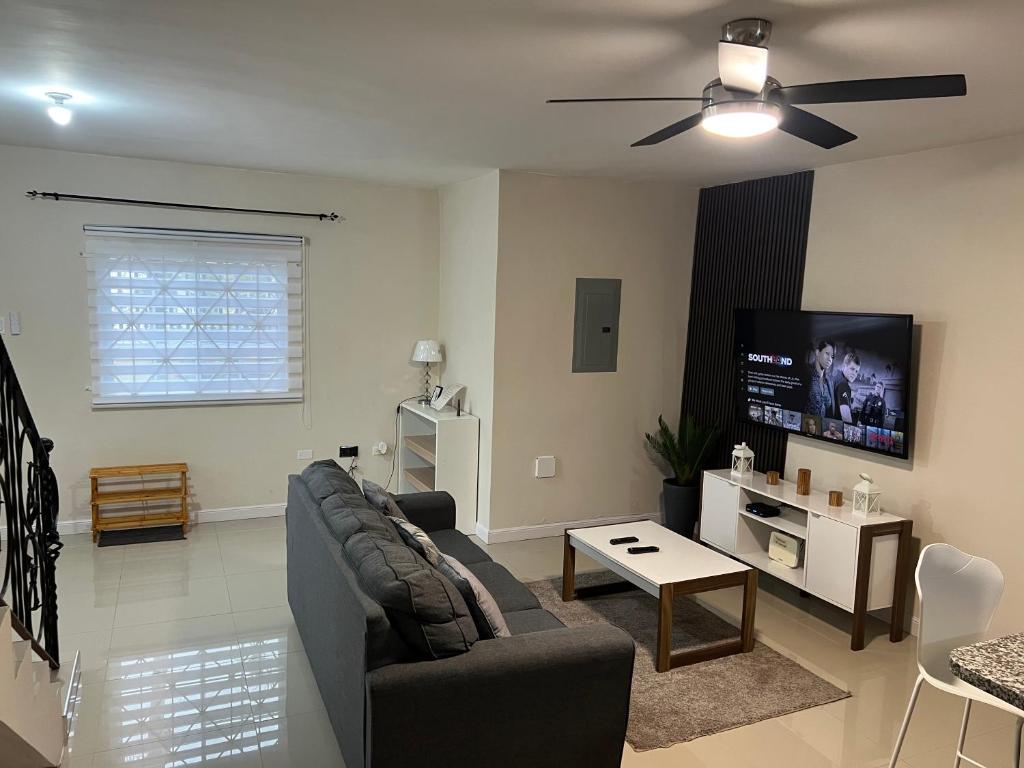 a living room with a couch and a flat screen tv at Mandeville luxury in Mandeville