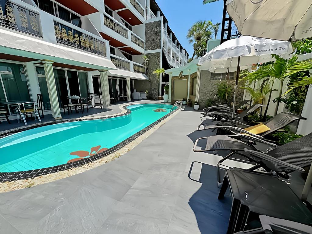 a resort with a swimming pool and lounge chairs at Orchid Hotel and Spa Kalim Bay in Patong Beach